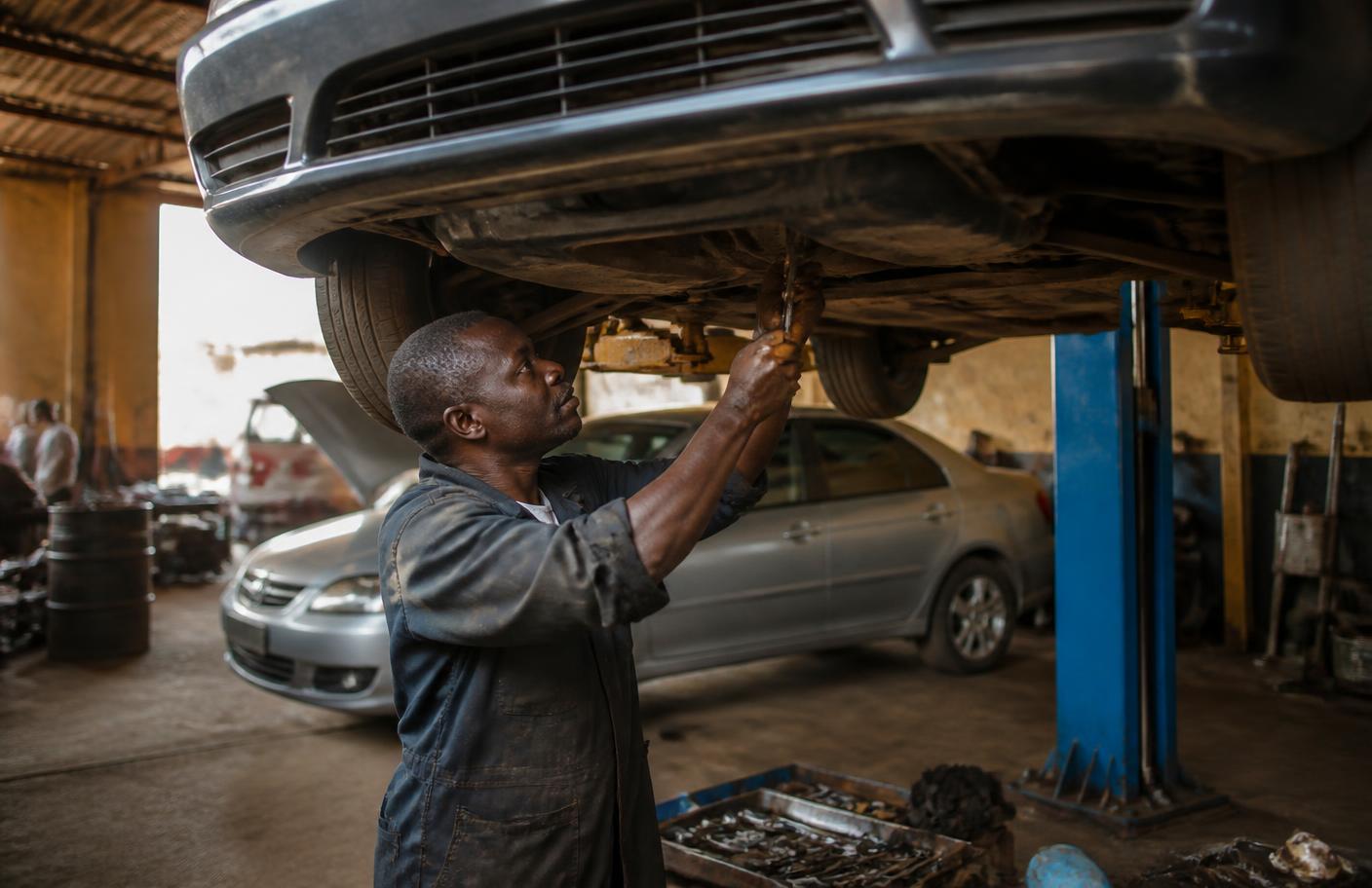 Mécanicien intervenant sur une berline dans un garage à Yaoundé